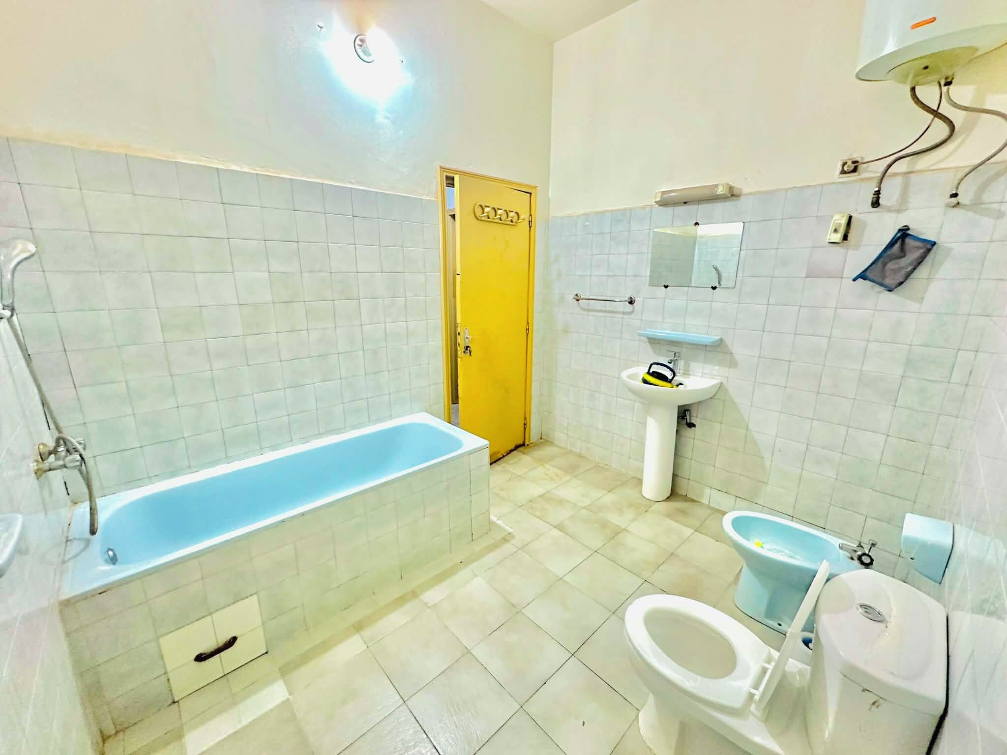 Een badkamer met een badkuip, wastafel, toilet en een spiegel.