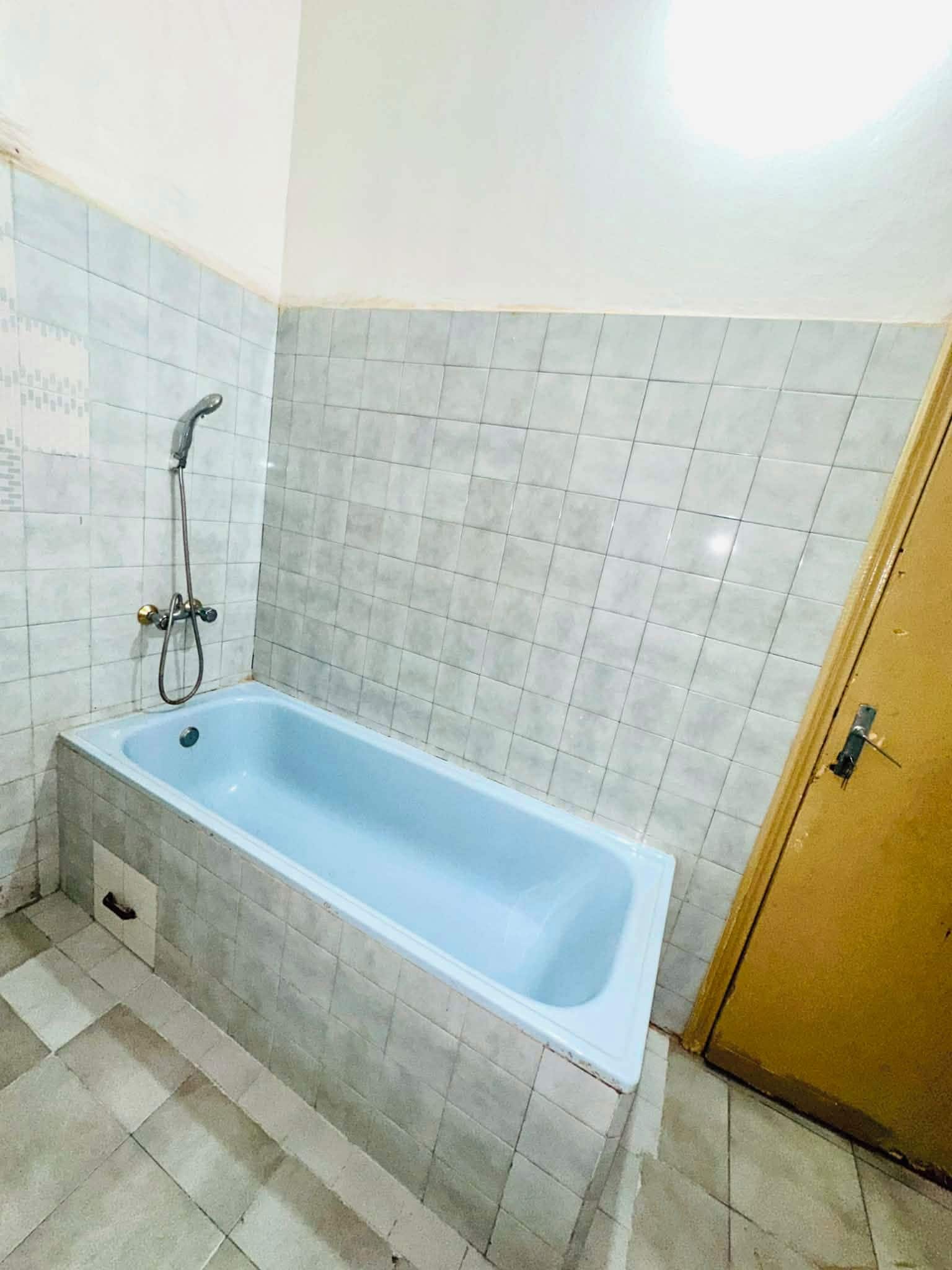 Un bagno con vasca, doccia e pareti piastrellate.