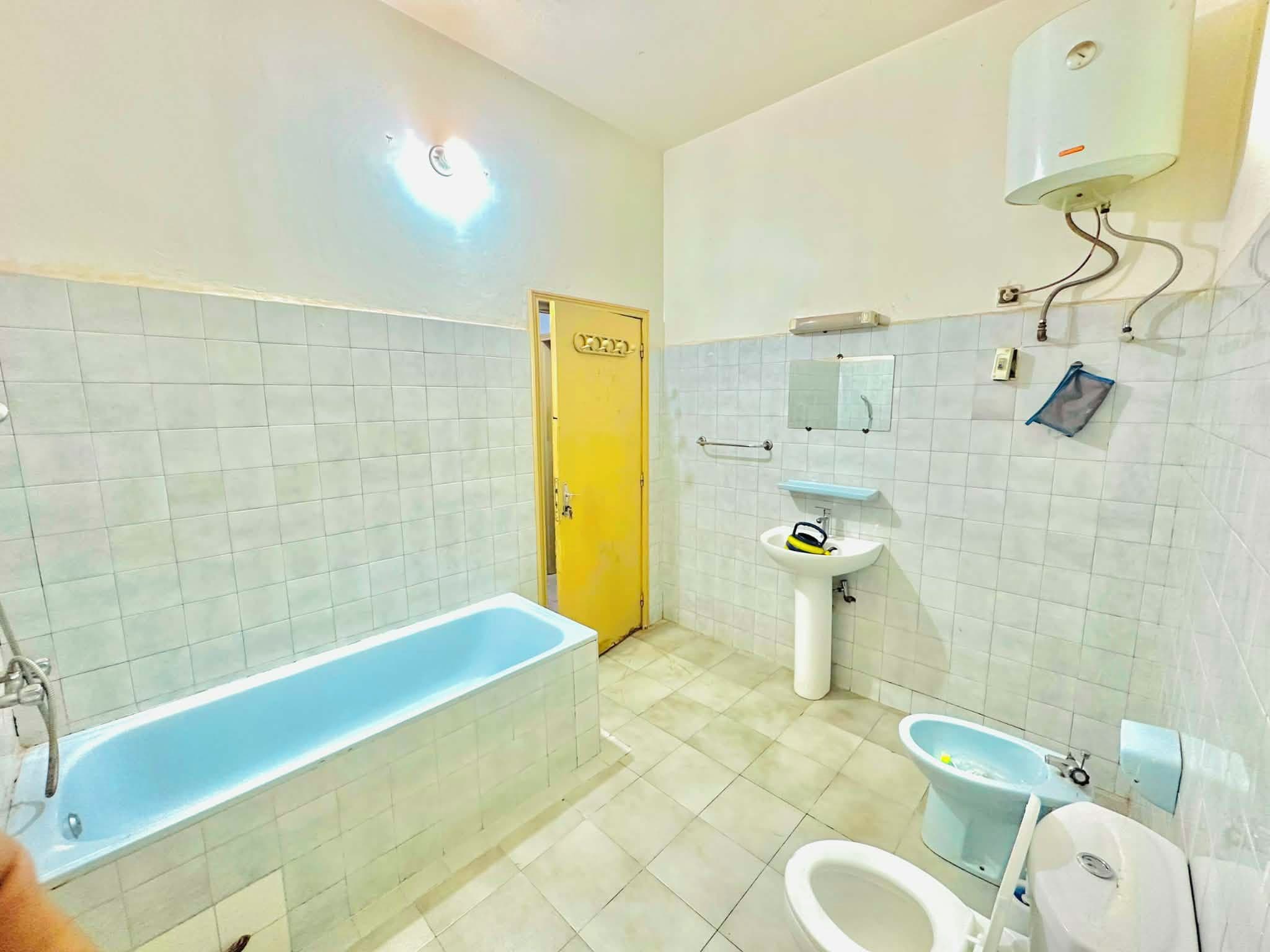 Een badkamer met een bad, wastafel en toilet.