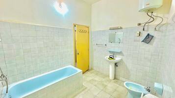 Een badkamer met een bad, wastafel en toilet.