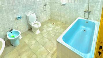 Un baño con bañera, inodoro y bidé.