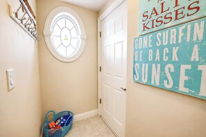 A hallway with a door, a wall-mounted clock, and a sign with text. - Laguna Vista 304 (Ocean City)
