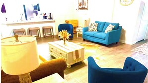 A living room with a blue sofa, a coffee table, and a lamp.