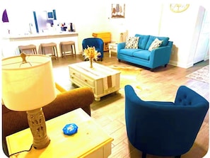 A living room with a blue sofa, a coffee table, and a lamp.