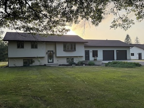 A two-story house with a front porch, a garage, and a well-maintained lawn. - Family Home Near Dells Waterparks | Papas' Legacy (Wisconsin Dells)