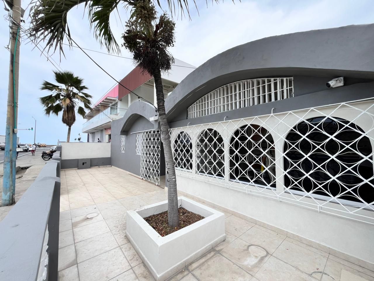Un bâtiment à l’architecture moderne, caractérisé par une façade incurvée et une série de fenêtres circulaires ornées d’un motif géométrique.
