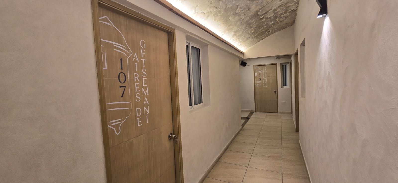 A hallway with a wooden door labeled '107' and 'GETSEMADENI'.