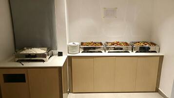 Montaje de bufé con diversas opciones de comida, como arroz, pasta y platos salteados.