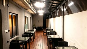 A corridor with tables and chairs, a potted plant, and a ceiling with lights. - Aotel Hotel Lagos Sobo (Lagos)