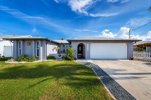 A single-story house with a garage, a front lawn, and a clear sky. - Waterfront Oasis - Stock Tank, Pool, Floating Dock & Kayaks (Hudson)