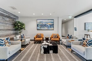 A modern lobby with two sofas, a coffee table, and a large abstract painting on the wall. - Luxury Condo w/ Resort Amenities, Walk to Gondola (Avon)