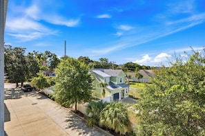 A residential area with a two-story house, a parked vehicle, and a clear sky. - Salt Air & Sunshine – 3BR/3BA Myrtle Beach Townhouse, Steps to the Beach (Myrtle Beach)