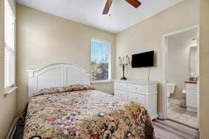 A bedroom with a bed, a dresser, a television, and a window with blinds. - Salt Air & Sunshine – 3BR/3BA Myrtle Beach Townhouse, Steps to the Beach (Myrtle Beach)