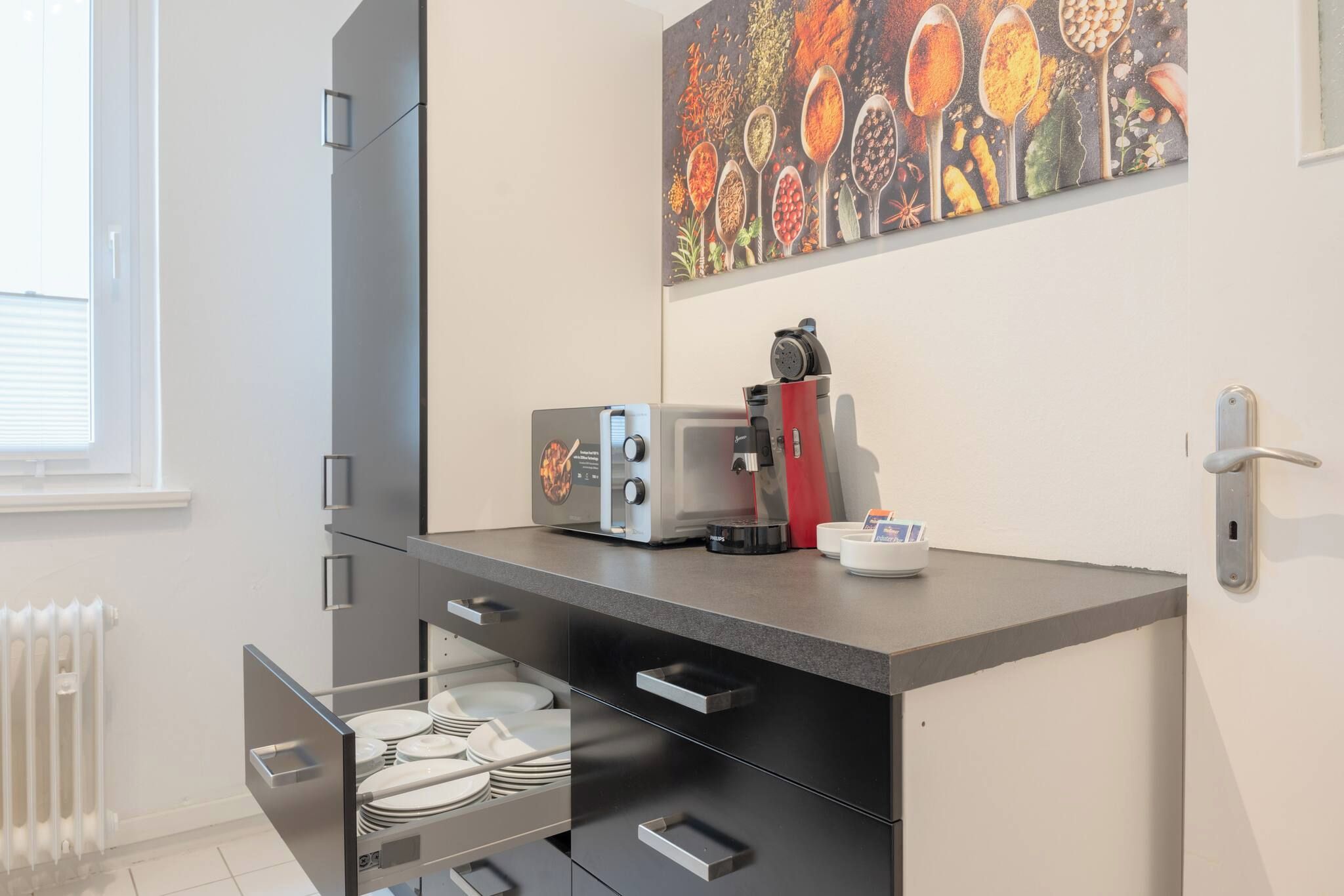 A kitchenette with a coffee machine, a toaster, and a dish rack.