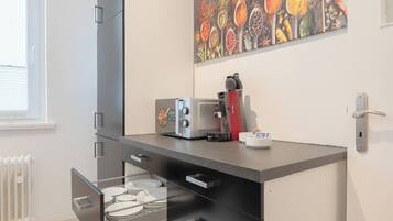 A kitchenette with a coffee machine, a toaster, and a dish rack.