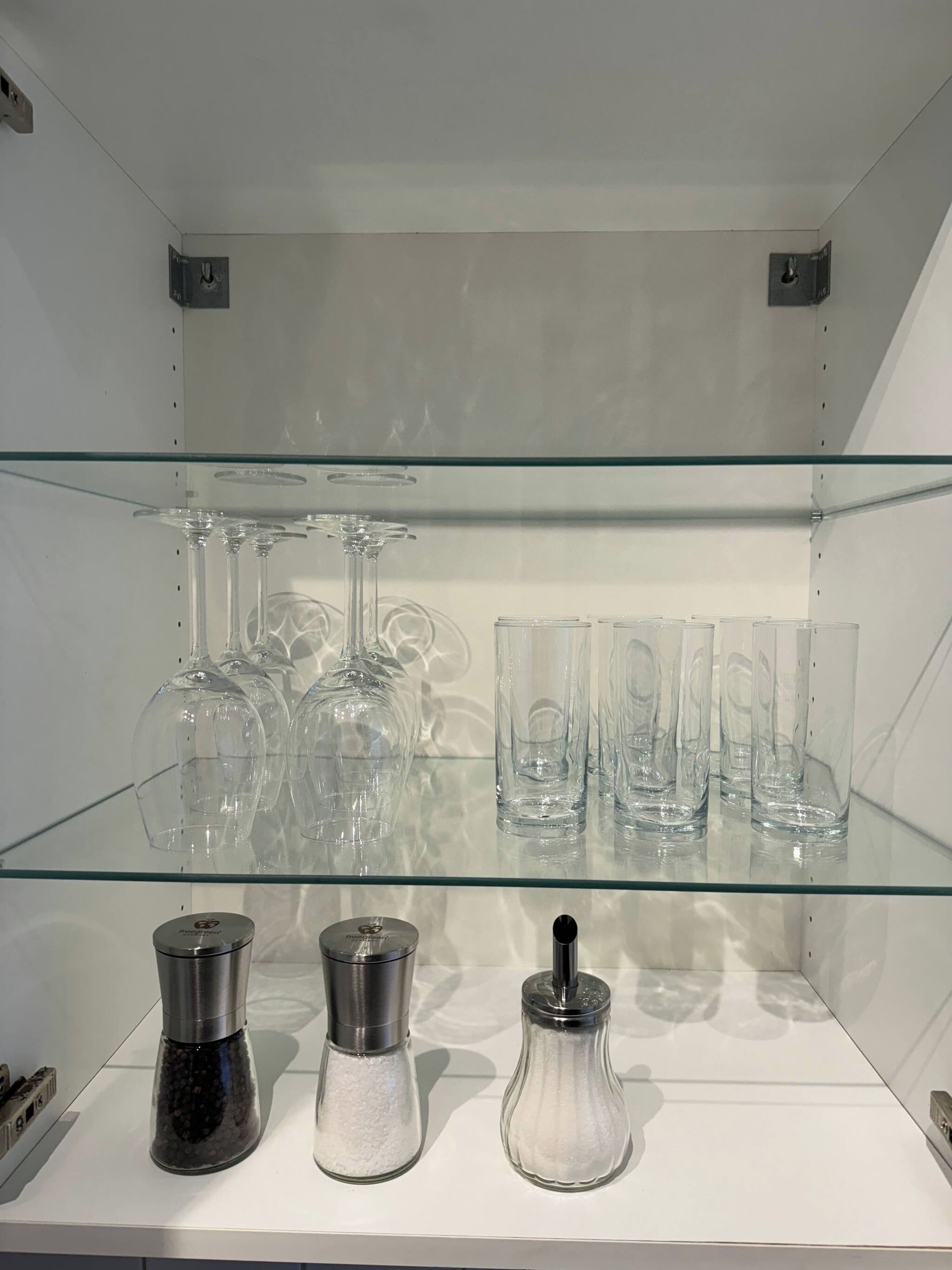 A glass display case with various glassware and salt shakers.