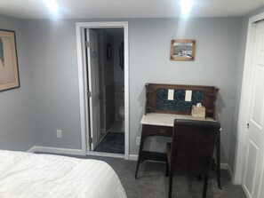 A bedroom with a bed, a desk, and a chair. There is a door leading to a bathroom. - 3 bedroom home on Main St Buena Vista, walking distance to EVERYTHING! (Buena Vista)