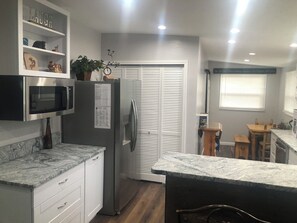 A modern kitchen with a built-in microwave, refrigerator, and granite countertops. - 3 bedroom home on Main St Buena Vista, walking distance to EVERYTHING! (Buena Vista)