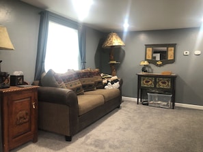 A living room with a sofa, a lamp, a small table, and a cabinet. - 3 bedroom home on Main St Buena Vista, walking distance to EVERYTHING! (Buena Vista)