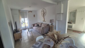 A living room with a sofa, a coffee table, and a lamp. There is a door leading to a balcony. - La maison zen Béthune  (Béthune)