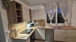A modern kitchen with a microwave, coffee maker, sink, and dishwasher. - La maison zen Béthune  (Béthune)