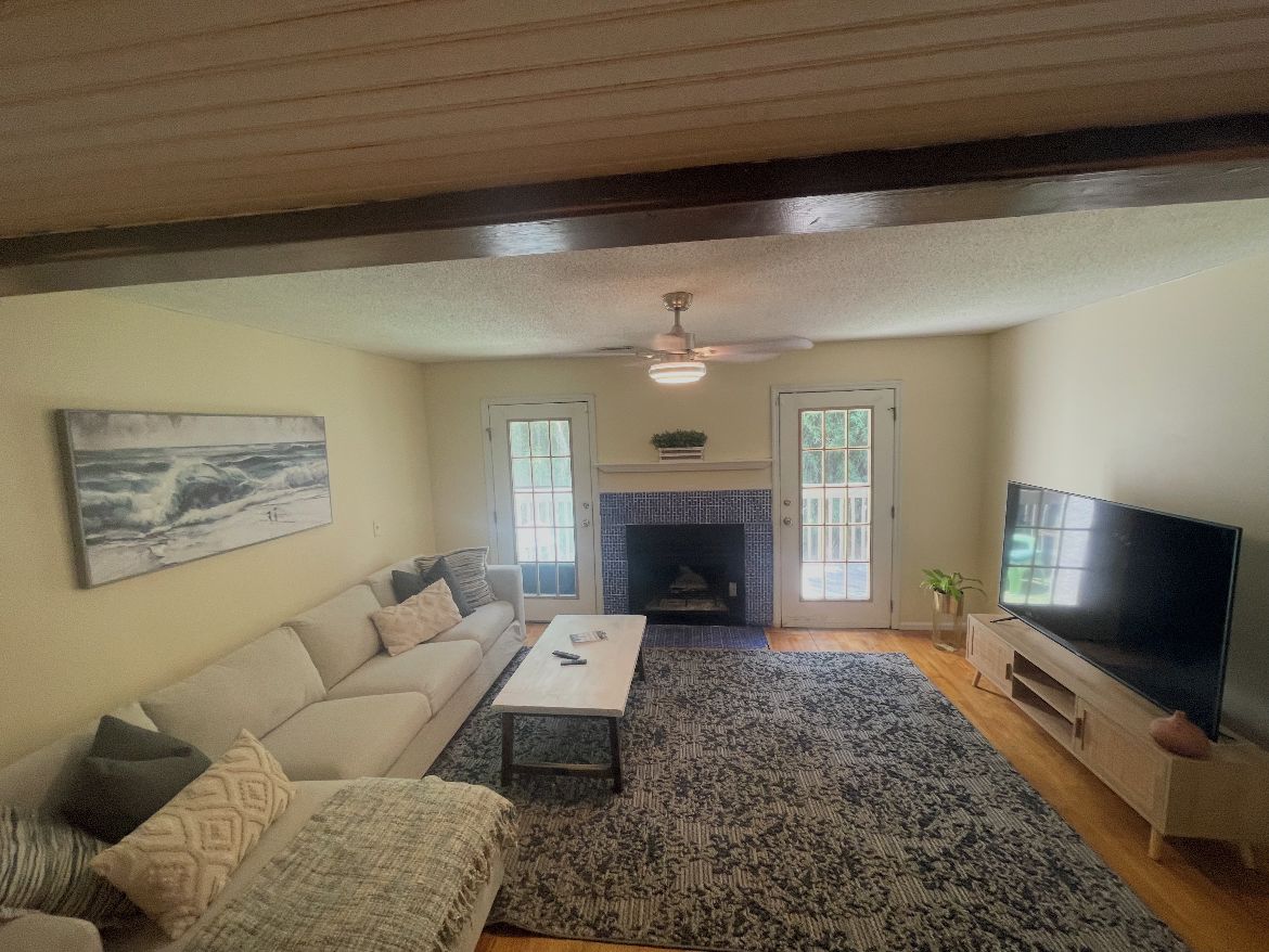 Una sala de estar con chimenea, televisor y sofá.
