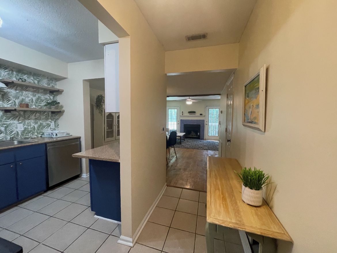A kitchen with blue cabinets, a wooden countertop, and a potted plant.