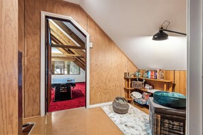 A room with a sloped ceiling, a billiards table, a bookshelf, and a hanging lamp. - Bella's Loft - Between Town and Trails (Margaret River)
