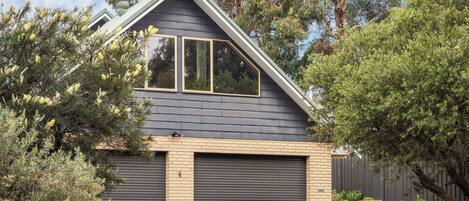 A residential house with a garage, a sloped roof, and a brick facade.