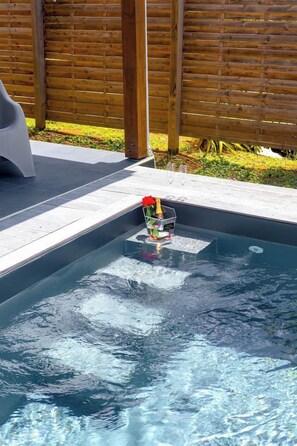 Ein Swimmingpool mit einer Champagnerflasche und Gläsern am Rand.