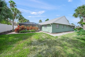 A single-story house with a green exterior, a covered patio, and a well-maintained lawn. - Spacious 4BR Villa on Siesta Key w/ Private Screened Pool & Lanai (Siesta Key)