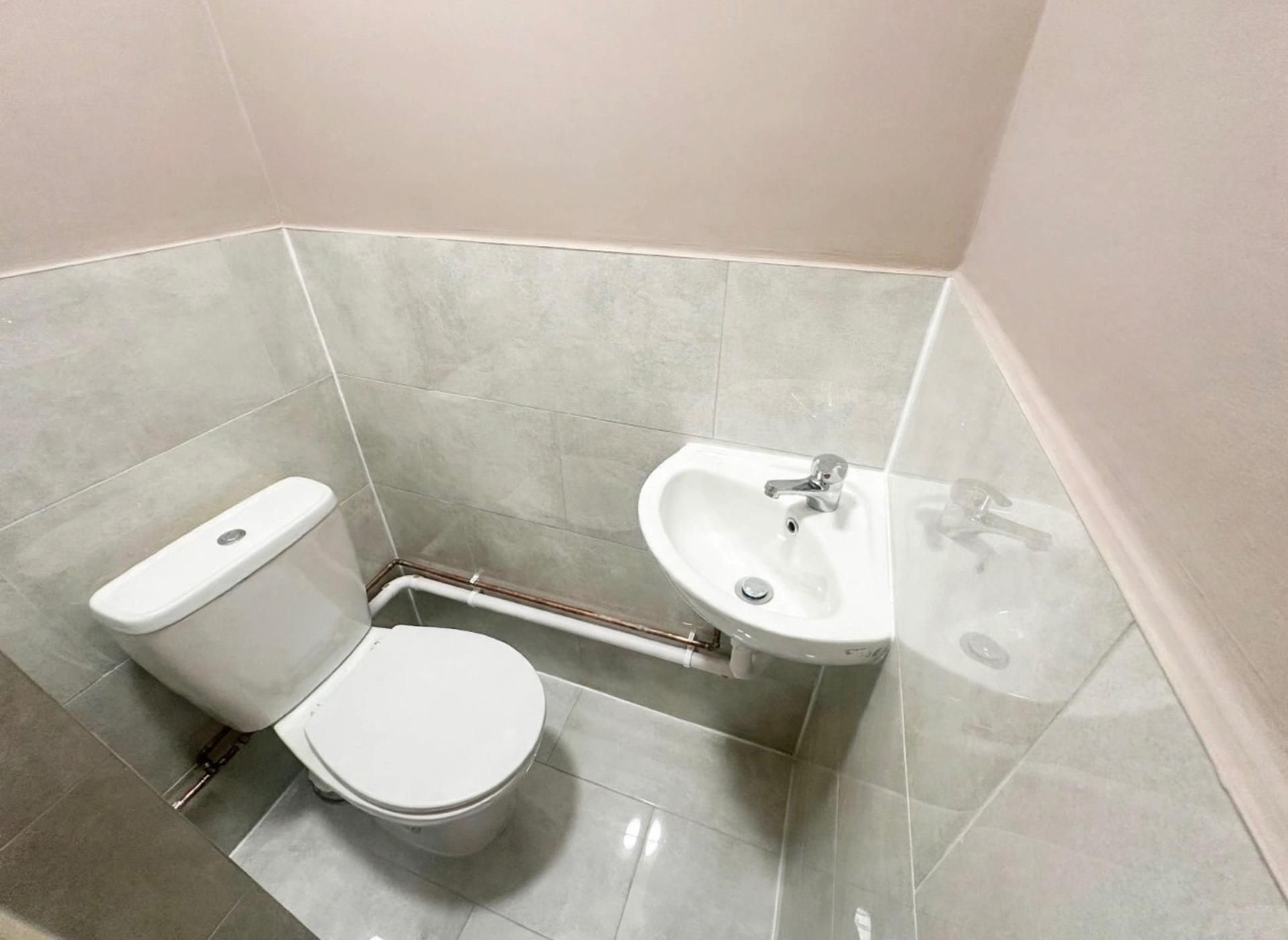 A small bathroom with a toilet, bidet, and sink.