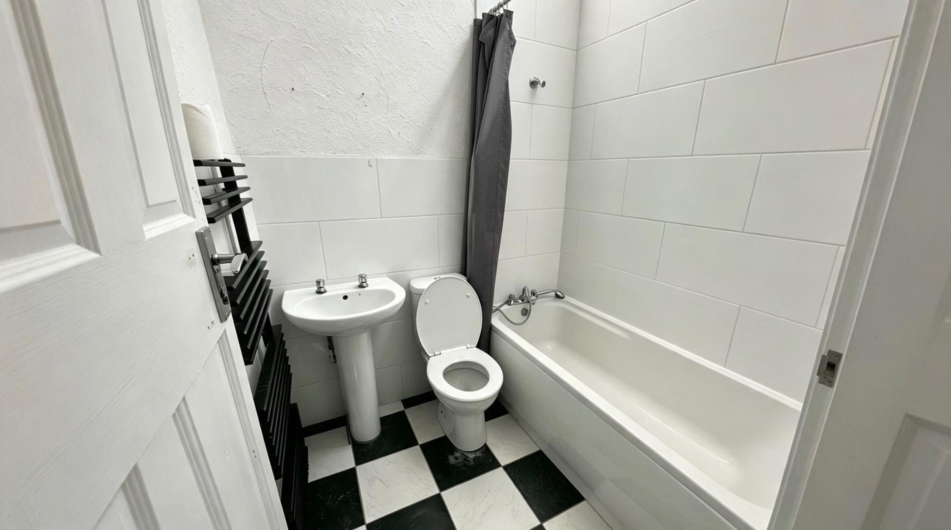 Une petite salle de bain avec des toilettes, un lavabo et une baignoire.
