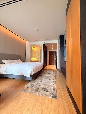 A modern hotel room with a large bed, a walk-in closet, and a bathroom with a glass shower enclosure. - @Discount 20% # Studio so cute & View Beach! (Đà Nẵng)