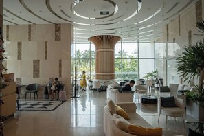 A spacious lobby with a central column, seating areas, and a check-in desk. - @Discount 20% vith 1br &Sofa Bed #View Beach&city! (Đà Nẵng)