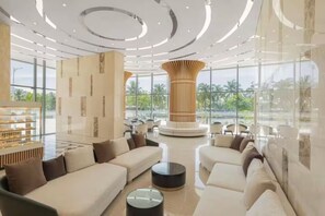 A spacious lobby with a central column, seating areas, and a glass facade offering a view of the outdoors. - @Discount 20% & 2 Bed Rooms Luxury #Ocean View! (Đà Nẵng)