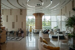 A spacious lobby with a central column, seating areas, and large windows. - @Discount 20% & 2 Bed Rooms Luxury #Ocean View! (Đà Nẵng)