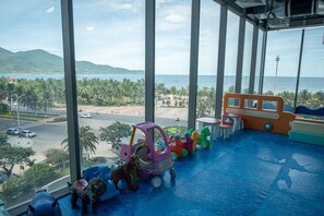 Ein Spielbereich für Kinder mit Blick auf eine Straße und Palmen.