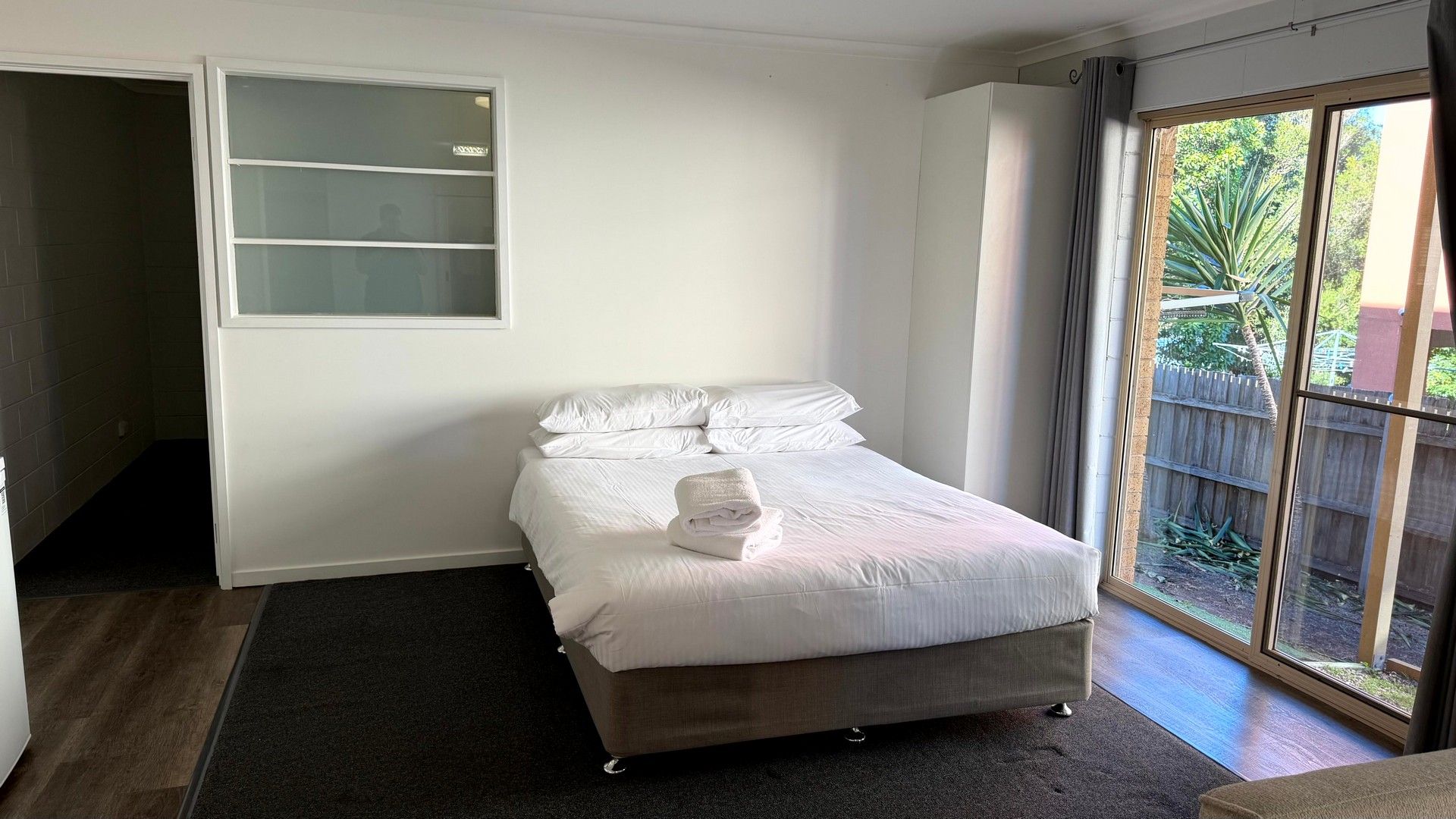Une chambre à coucher avec un lit, une fenêtre et une porte.