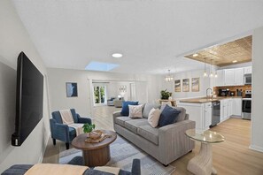 Un salon moderne avec un canapé, une table basse et un téléviseur.