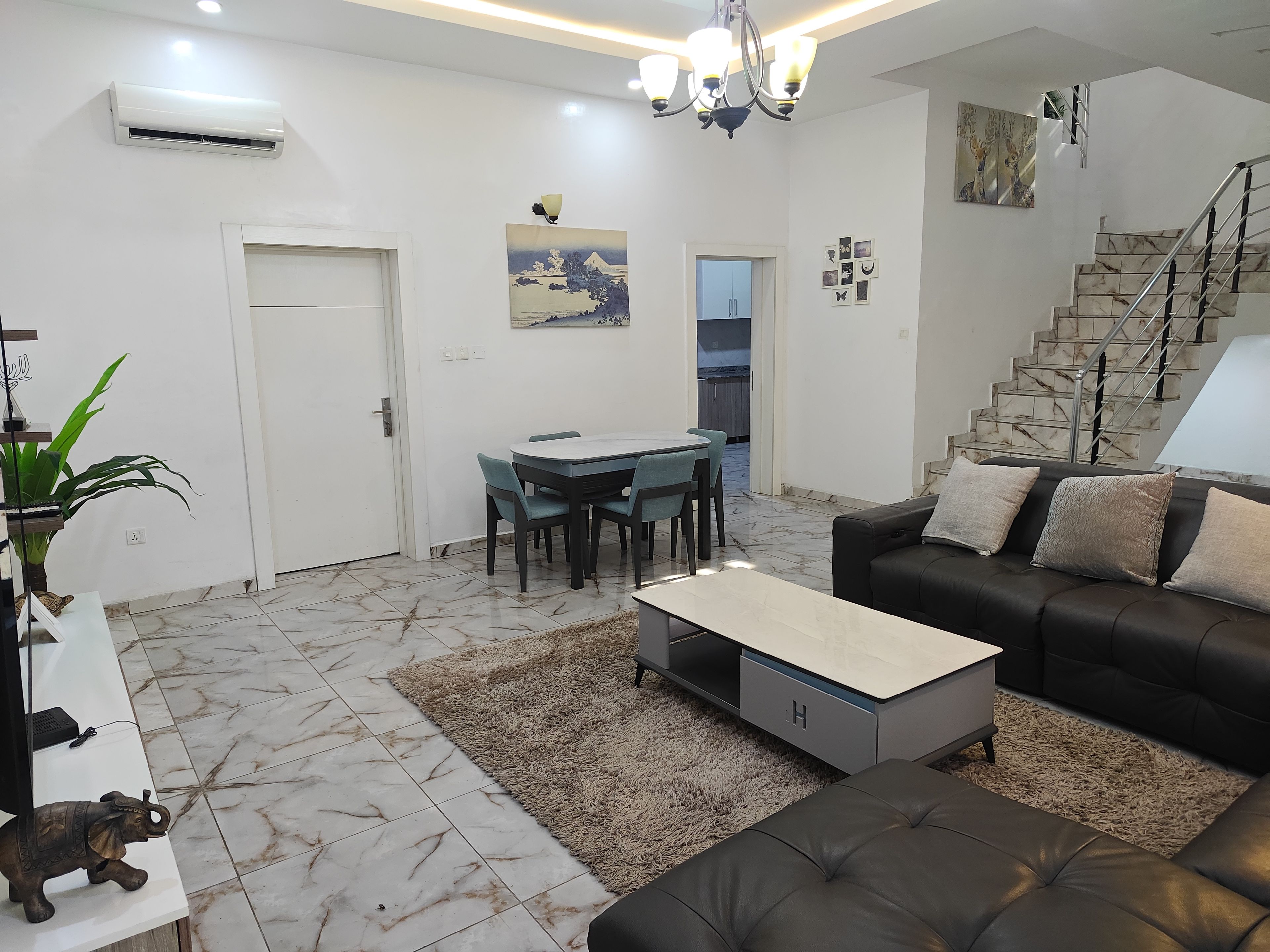 Una sala moderna con un sofá, una mesa de centro y un comedor con sillas.