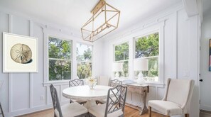 A dining area with a round table, chairs, and a pendant light. - New to Market-Gorgeous 3 BR, sleeps 8, close to all, both clubs avail (Bald Head Island)