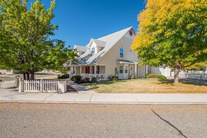 A two-story residential house with a gabled roof, a front porch, and a well-maintained lawn. - Base Camp: Downtown Charm Dogs Welcome! (Fruita)