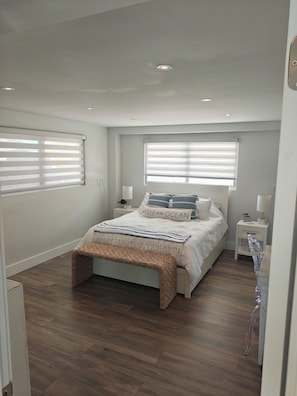 A bedroom with a bed, bedside tables, a bench, and a window with blinds. - Coastal 1 Bedroom Unit with 40 foot boat slip (Tavernier)
