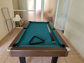 A pool table with a triangular rack, two cue sticks, and a wire rack. - Beautiful villa with a garden and pool near the beach (CT)