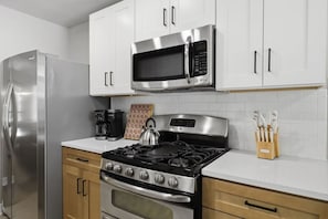 A modern kitchen with stainless steel appliances, including a refrigerator, microwave, and stove. - Resort Getaway: Pool, Hot Tub & Putting Green (San Antonio)