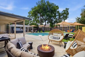 A backyard with a pool, outdoor furniture, and a fire pit. - Resort Getaway: Pool, Hot Tub & Putting Green (San Antonio)