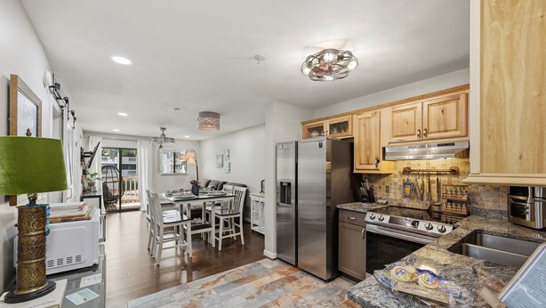 A modern kitchen with stainless steel appliances, wooden cabinets, and a granite countertop. - Steps to beach & pools  Cozy 2-bedroom 2 bath condo in Hilton Head Island (Hilton Head Island)