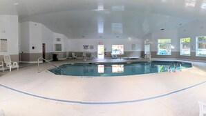 An indoor swimming pool with clear pool rules posted on the wall, a lifeguard chair, and a poolside area with chairs and a sunshade. - Steps to beach & pools  Cozy 2-bedroom 2 bath condo in Hilton Head Island (Hilton Head Island)