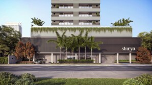 Een modern gebouw met een plat dak, een verticale tuin en een bord waarop 'stoya' staat.
